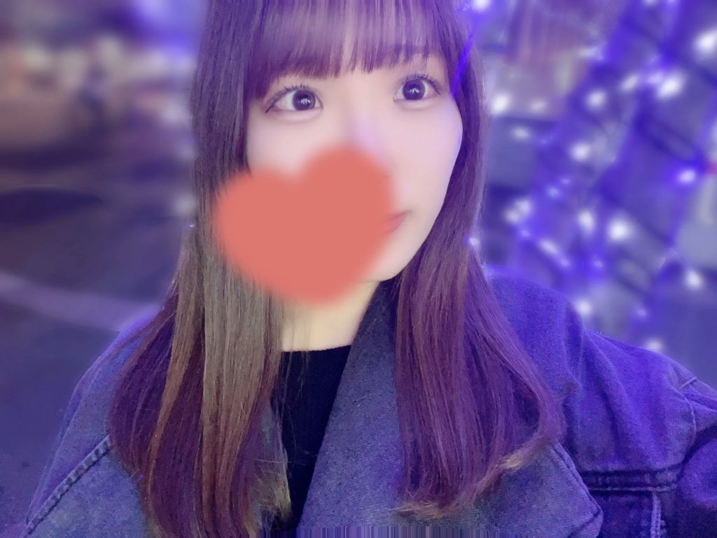 DXLIVEのIORIosちゃんがベッドにちょこんと座って微笑む癒し系Eカップ学生のイメージ画像